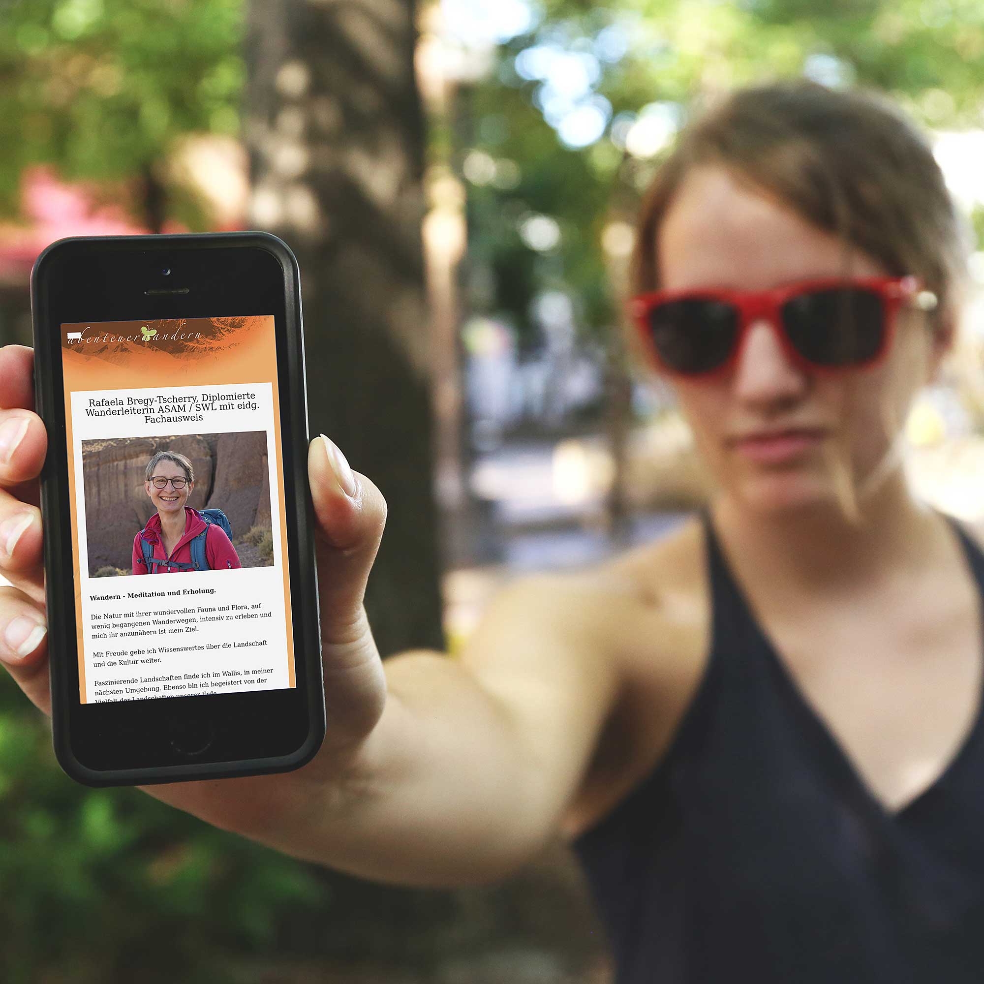 Abenteuer Wandern: Frau mit Smartphone und offener Webseite